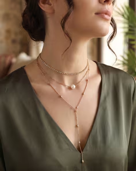 Woman wearing layered gold necklaces